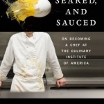 In the upper third a breaking egg shoots across a black background, in the lower two thirds a chef leans against the counter, shown from neck to waist